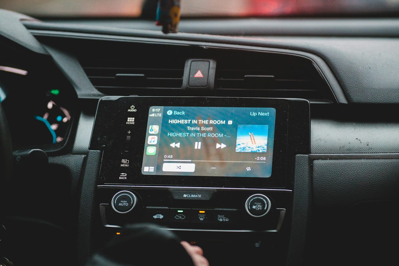 An automotive infotainment touch panel set into a car dashboard, playing audio. The touch screen and the speaker system run from the same supply and share the same ground.